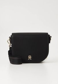 Sort skinnveske med skulderrem, med gullfarget logo, buet klaffdesign og justerbar stropp med detaljert metallpynt.