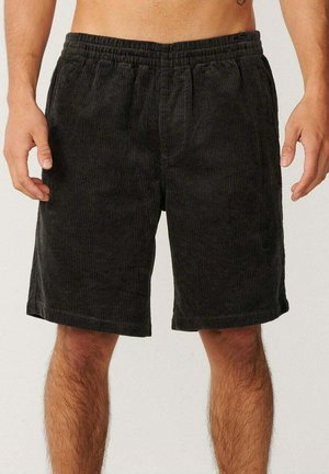 Sorte manchester-shorts med elastisk talje, knælængde og lodret ribbet tekstur. Ingen lommer eller ekstra detaljer synlige.