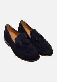 Marineblauwe suède instappers met kwastjes, voorzien van een slip-on ontwerp, een ronde neus en een bruine leren zool voor een klassieke uitstraling.