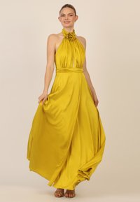 Gelbes Maxikleid aus glattem Stoff, mit Halterneck, plissiertem Oberteil und floralem Akzent am Halsausschnitt. Fließende Silhouette.