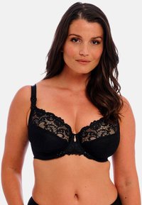 Musta pitsinen rintaliivi, jossa on muotoileva tuki, kukkakuvioinen pitsikuvio ylhäällä ja pieni keskikoriste. Pehmeä kangaspohja.