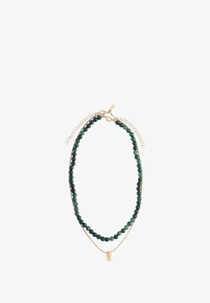 Keratan kalung berlapis dengan manik bulat hijau gelap dan rantai emas tipis yang menampilkan pendant emas tidak teratur kecil, keduanya dilengkapi dengan pengait lobster emas dan rantai perpanjangan.
