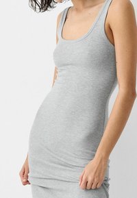 Robe débardeur gris côtelé, coupe ajustée, larges bretelles, texture douce et design sans couture avec une légère élasticité.