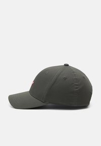 Gorra de béisbol verde oscuro con visera curvada, diseño de seis paneles, acentos cosidos y un pequeño logo en la parte frontal.