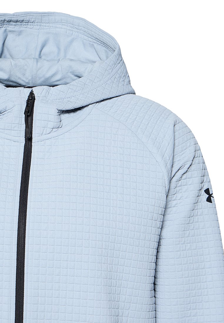 Veste matelassée zippée bleu clair avec capuche, fermeture éclair noire et logo Under Armour sur la manche gauche.