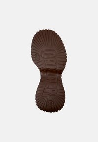 Braune Gummisohle eines Sneakers mit ausgeprägten Rillen, die das 'CAMPEL'-Logo und die Größe '38' in die Mitte geprägt aufweist. Flache, strukturierte Oberfläche.