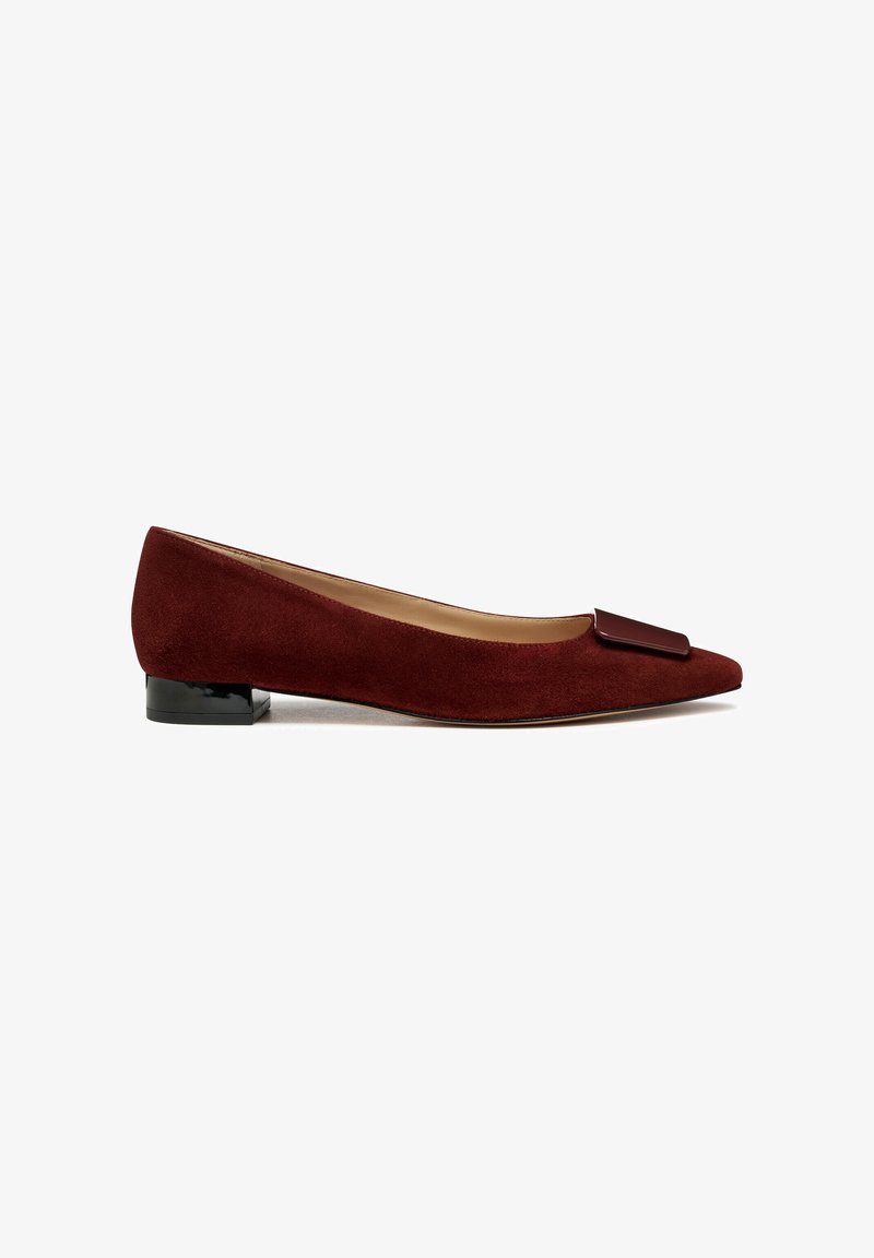 Bordeaux suède ballerina met een puntige neus en een rechthoekige zwarte accent op de wreef. Lage, transparante zwarte hak. Soepele textuur.