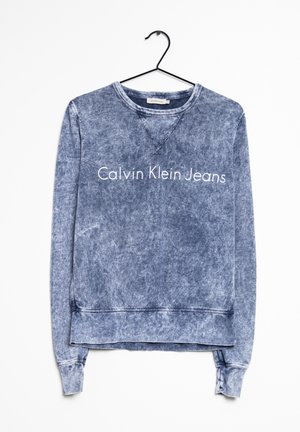 Felpa blu sbiadita realizzata in misto cotone, con polsini e orlo a coste, con la scritta "Calvin Klein Jeans" stampata sul davanti.