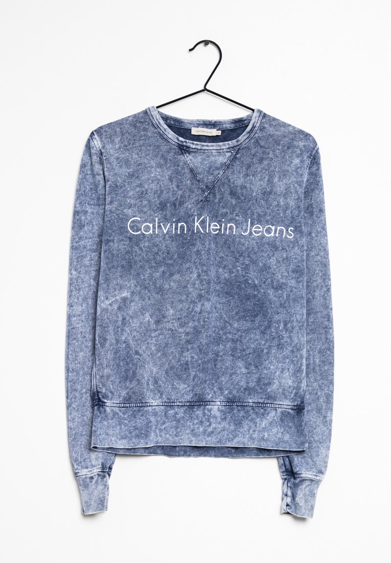 Blekt blå sweatshirt gjord av bomullsmix, med ribbade mudd- och fållkanter, med texten "Calvin Klein Jeans" tryckt över framsidan.