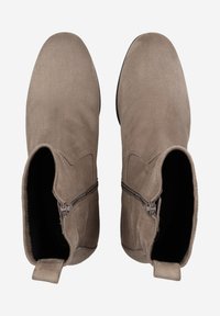 Bottes chelsea en suède marron avec une texture lisse, un bout arrondi, des fermetures éclair sur les côtés et une tige courte. L'intérieur est doté d'une doublure sombre.