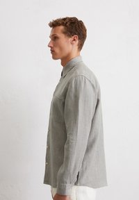 Gestreiftes Button-up-Hemd in einem sanften Grün-weiß-Farbton, mit einer Brusttasche, Kragen und umgeschlagenenÄrmeln im lässigen Schnitt.