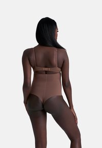 Costume da bagno intero marrone con spalline regolabili, chiusura posteriore e finitura liscia e testurizzata. Taglio a vita bassa sul retro.
