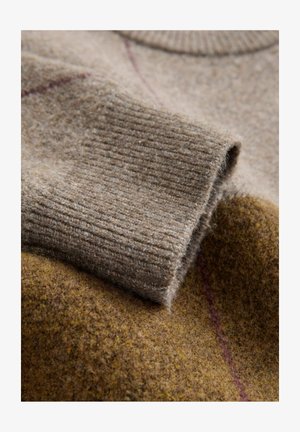 Villapaita ruskeissa sävyissä, jossa on ribattu hihansuu, pehmeä rakenne ja hillitty viininpunainen raita tummemman ruskean taustan päällä.