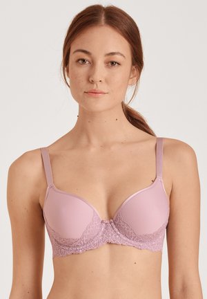 Lichtroze bh met gladde cups en delicate kantdetails op de band, verstelbare bandjes en een haaksluiting aan de voorkant.