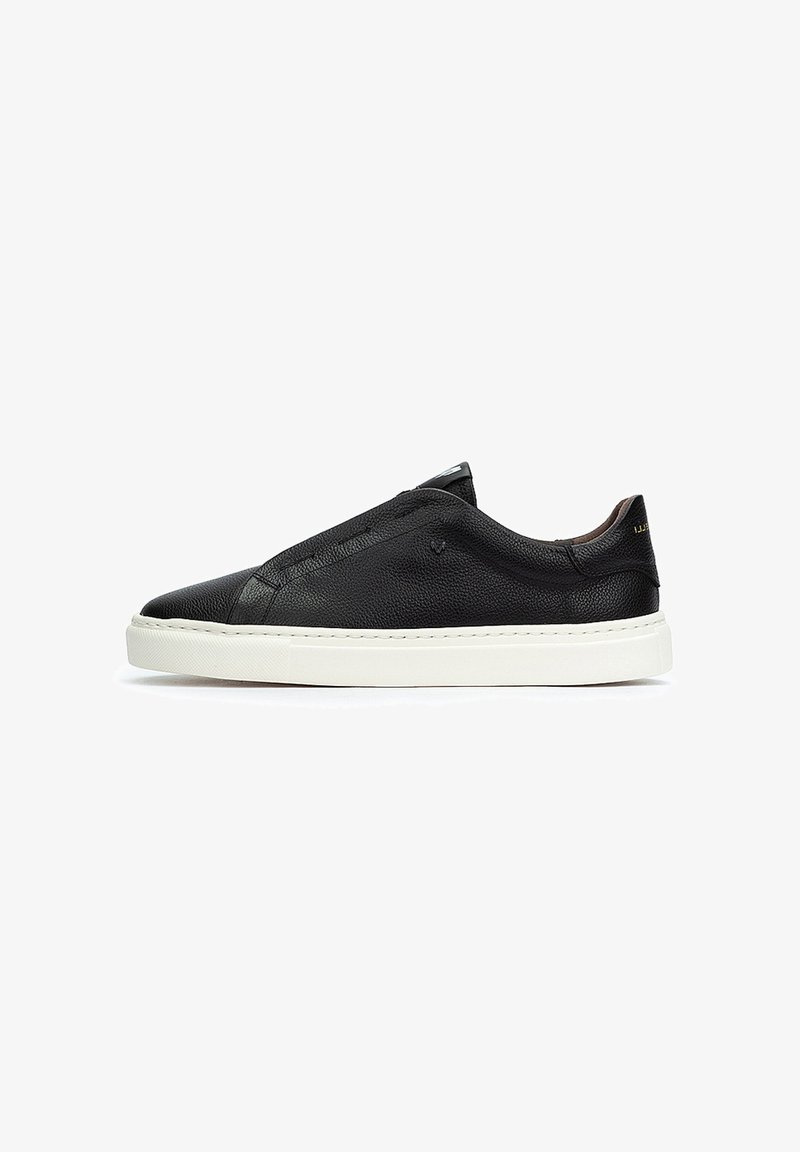 Baskets slip-on en cuir noir avec une finition texturée, semelle en caoutchouc blanc et détails de couture minimalistes. Présente un bout arrondi et un design bas.
