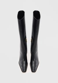 Bottes en cuir noir hautes jusqu'aux genoux avec un design épuré et ajusté, un bout pointu et des accents en métal doré sur les fermetures éclair.