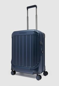 Marineblauer Hartschalenkoffer mit vertikalen Rillen, ausziehbarem Griff, zwei Rollen, Reißverschluss und Logo oben.