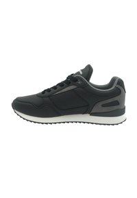 Chaussure de sport noire avec une tige synthétique lisse, un design à lacets, des accents gris, et une semelle intermédiaire blanche avec une semelle extérieure en caoutchouc texturée.