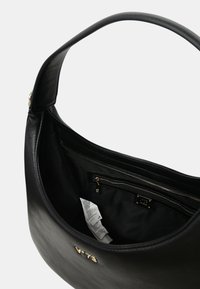 Zwarte leren handtas met een ronde vorm, een gladde textuur en een binnenvak met rits. Bevat hardware in goudkleur en een logo-accent.