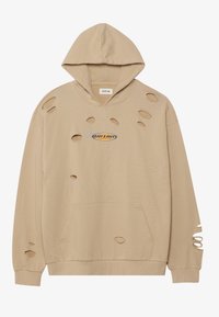 Béžová mikina s kapucí a přední kapsou, s několika prodřenými dírami a modro-oranžovým vyšívaným logem na hrudi.