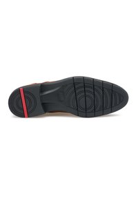 Sole di scarpa marrone con gomma nera testurizzata, motivo di battistrada circolare e accento rosso. Presenta un leggero tacco e un design resistente.