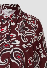 Bordeaux overhemd met knopen, versierd met abstracte bloem- en paisleydesigns in wit, rood, grijs en zwart, met een puntige kraag.