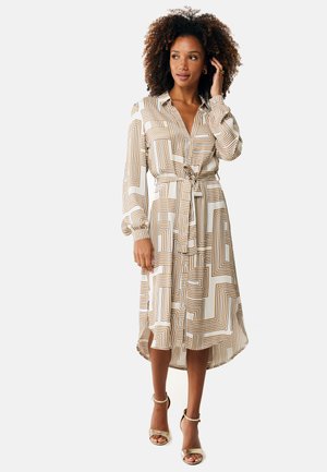 Vestido de manga larga con un patrón geométrico en tonos beige y dorado. El material tiene una textura suave; incluye una cintura ceñida con cinturón y cierre de botones.