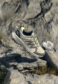 Trail running topánky Columbia v svetlej béžovej a šedej farbe. Vrchný materiál z priedušného sieťovinového textilu s textúrovanými detailmi, gumová podrážka a reflexné akcenty. Ľahká konštrukcia.