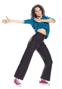 Teal kratki top uparen s crnim hlačama širokog kroja koje imaju visoki struk i ružičastim tenisicama. Outfit se odlikuje čistim linijama i modernim dizajnom.