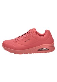 Obuwie marki Skechers w matowym kolorze koralowym, z gładką syntetyczną cholewką, perforowanymi akcentami, wyściełanym kołnierzem i widoczną poduszką powietrzną.