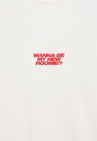 Tessuto bianco con testo rosso ricamato al centro che recita "VUOI ESSERE LA MIA NUOVA COMPAGNA DI STANZA?" in lettere maiuscole.