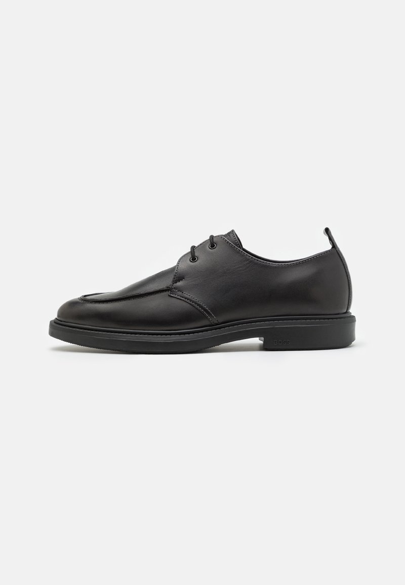 Chaussure habillée pour homme en cuir noir avec fermeture à lacets, bout arrondi et talon bas, vue de profil sur fond blanc.