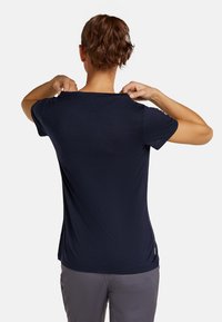 Navy blue t-paita, joka on valmistettu pehmeästä kankaasta, ja siinä on lyhyet hihat sekä rento.fit. Tasainen tekstuuri, pyöreä kaula-aukko ja ilman näkyviä kuvioita.