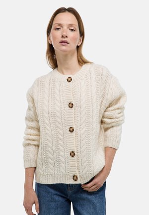 Cardigan en mailles torsadées crème avec un col rond, une coupe oversize et des boutons marron. Motif texturé sur l'ensemble avec des manches longues côtelées.