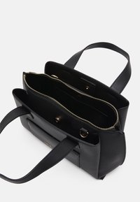Black leather tote bag with textured exterior, dual top handles, gold zippered compartments, and a sleek design. Interior includes pockets.