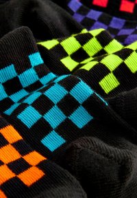 Calzini di cotone colorati con fondo nero, caratterizzati da un motivo a scacchiera in turchese, verde, viola, rosso e arancione.