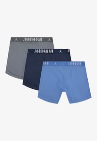 Trijų šortų rinkinys: pilki, tamsiai mėlyni ir mėlyni. Kiekvienuose yra elastingas juosmuo su užrašu „JORDAN“ ir lygus, tamprus audinys.