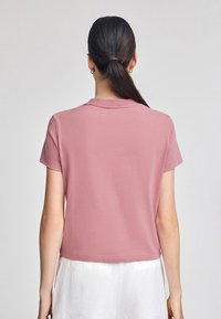 Kortärmad, rosa bomulls t-shirt med en avslappnad passform. Har en rund hals och en ren, enkel design utan synliga logotyper.