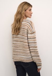 Maglione a maglia con strisce orizzontali in crema, beige e azzurro chiaro. La texture morbida, le spalle scese e i polsini a costine aggiungono dettagli.