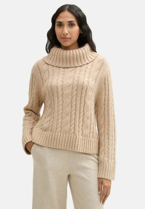 Pull en tricot beige avec un col montant à côtes, présentant un motif en câble, des manches longues et un design court. Tissu texturé doux.