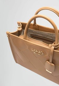 Borsa a tracolla trapuntata beige con hardware dorato, doppi manici e tasca interna con zip. Presenta il nome del marchio "Liu Jo Milano" in oro sul davanti.