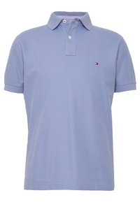 Ljusblå polotröja i bomull, med krage, tre knappar och en liten logga på vänster bröst. Kort ärm.