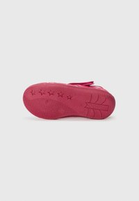 Pink rubber shoe sole with textured surface, featuring star patterns and brand logo. Flat, rounded edge with durability indicators.