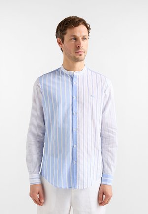 Hemd zum Zumknöpfen mit abwechselnden vertikalen Streifen in Hellblau und Weiß. Verfügt über einen Stehkragen, lange Ärmel und einen abgerundeten Saum.