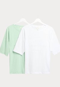 Twee t-shirts op hangers: één mintgroen en één wit. Het witte shirt heeft een textuurprint met de woorden "RELAX REPEAT."