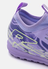 Scarpa sportiva viola con tomaia texturizzata, un loop per il pull tab e accenti neon. Il design include motivi astratti e branding.