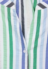 Randig skjorta med knappar som har vertikala ränder i grönt, blått och vitt. Tyget är lättviktigt och har krage samt knapppdetaljer.