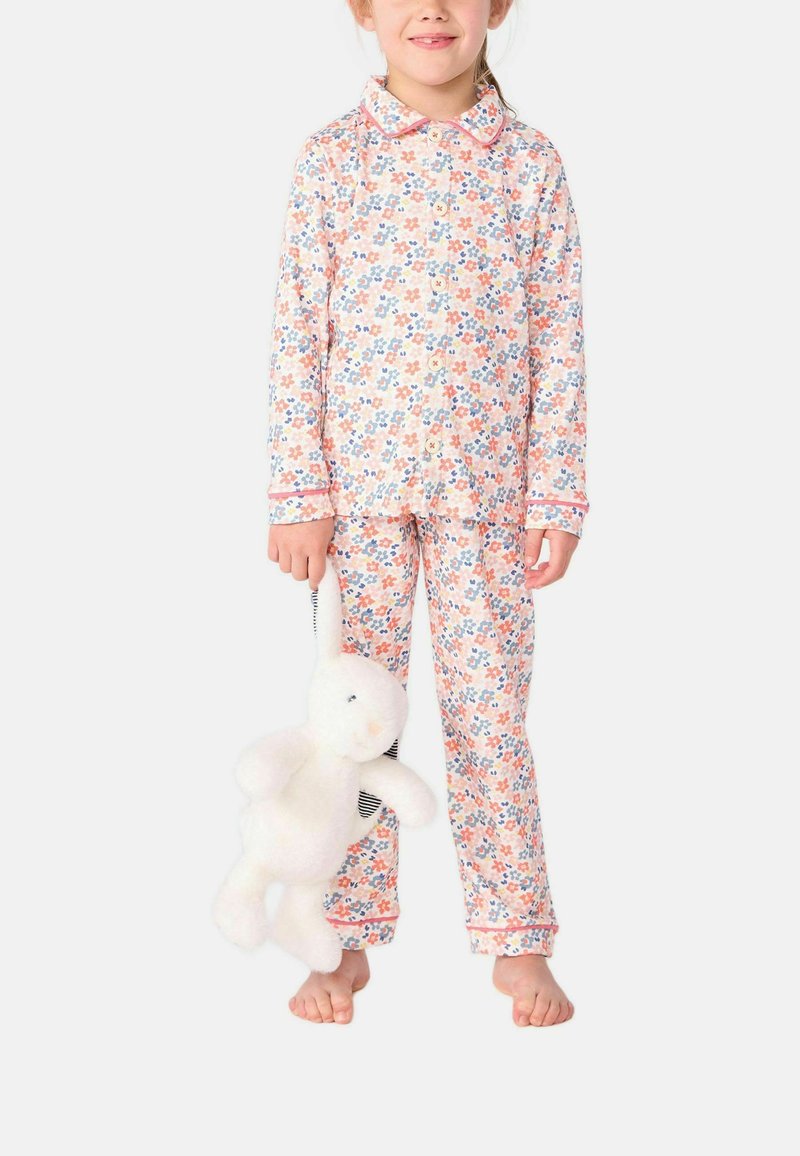 Ensemble de pyjama à manches longues avec un motif floral de fleurs roses, bleues et jaunes. Tissu doux avec un contraste en rose; peluche de lapin blanc en main.