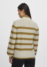 Strickpullover mit hohem Kragen, der auffällige olivgrüne und cremefarbene horizontale Streifen, einen gerippten Saum und überschnittene Schulternähte aufweist.