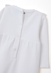 Weißes langärmeliges Kleid mit strukturiertem Stoff, rundem Ausschnitt, Knopfverschluss auf der Rückseite und gerafftem Taillendetail.